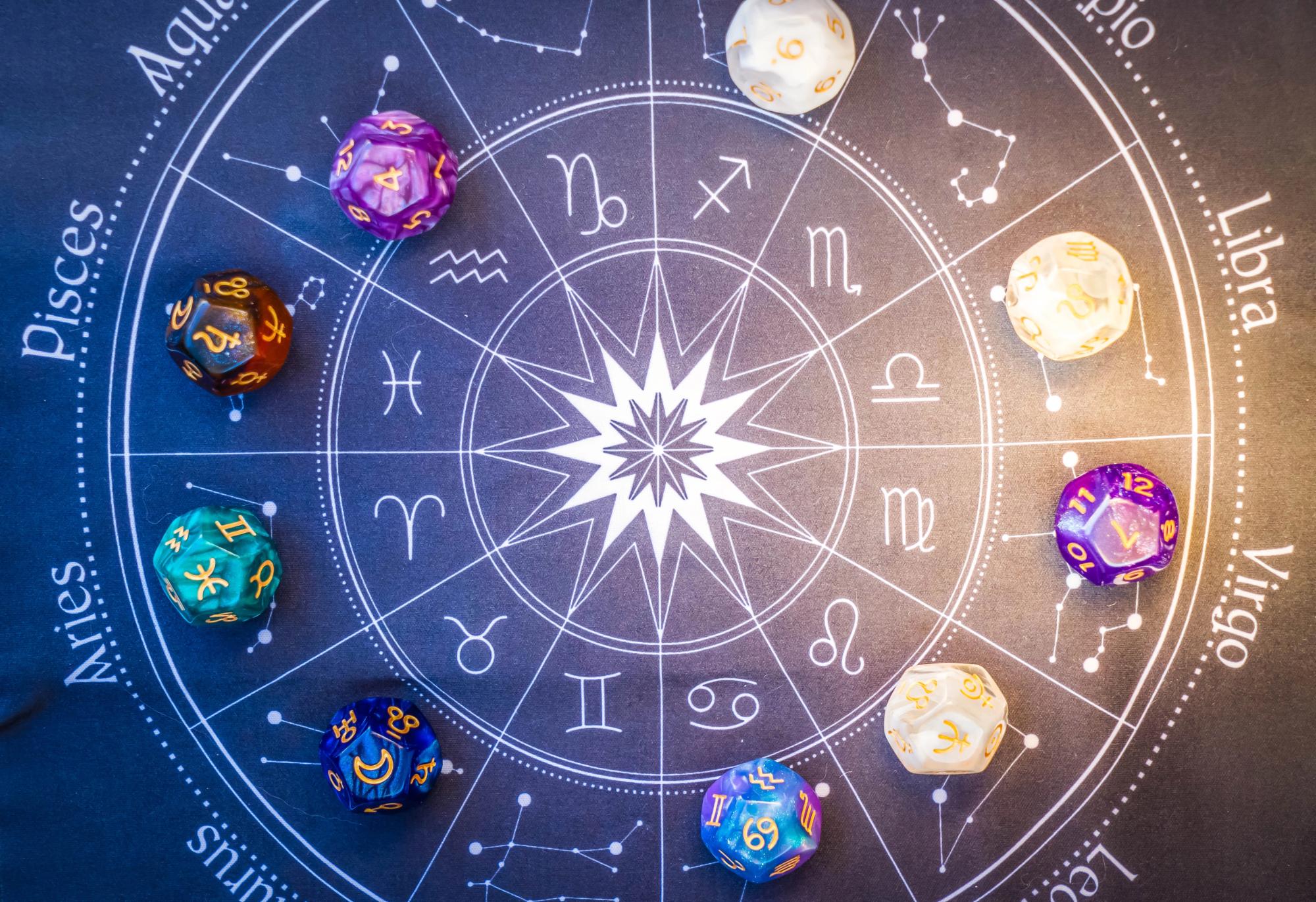 Colorful dice representing zodiac signs arranged on an astrological chart
