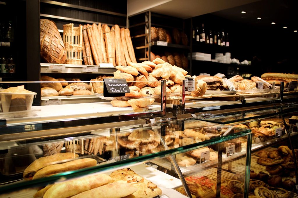 A bakery display filled with a variety of fresh breads and pastries.