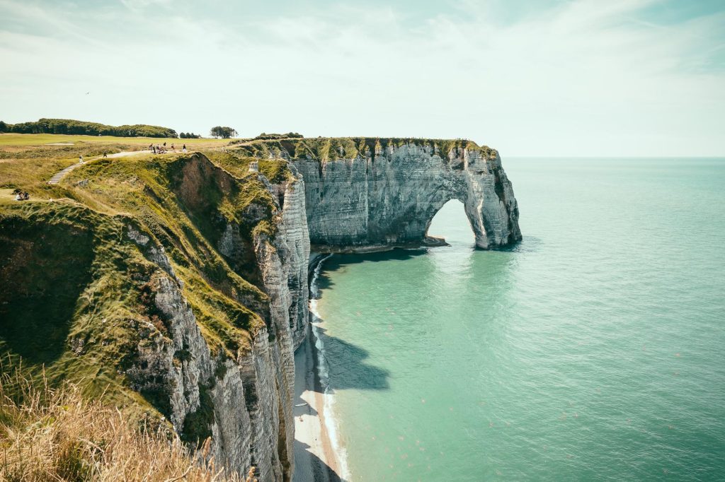 A picturesque view of the cliffs of Etretat in Normandy, France, showcasing the natural arch and turquoise waters.