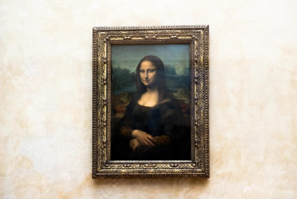 The Mona Lisa, a famous painting by Leonardo da Vinci, displayed in an ornate frame against a light background.