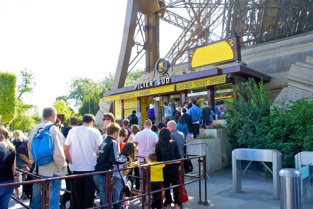 A long line of visitors waiting to buy tickets at the Eiffel Tower's South Pillar ticket office.