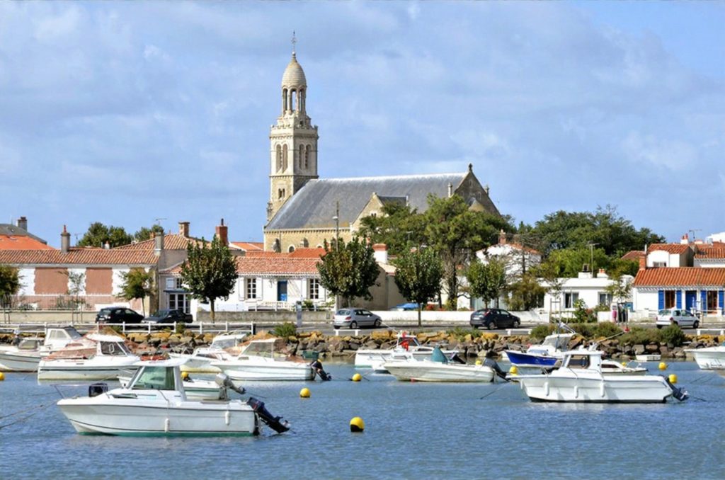 View of Saint-Gilles-Croix-de-Vie with boats in the foreground and a church in the background.