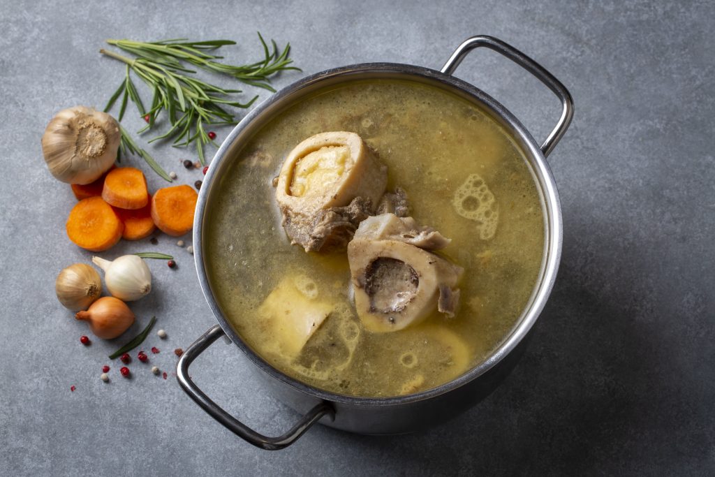 Boiled bone and broth. Homemade beef bone broth is cooked in a pot on. Bones contain collagen, which provides the body with amino acids, which are the building blocks of proteins.