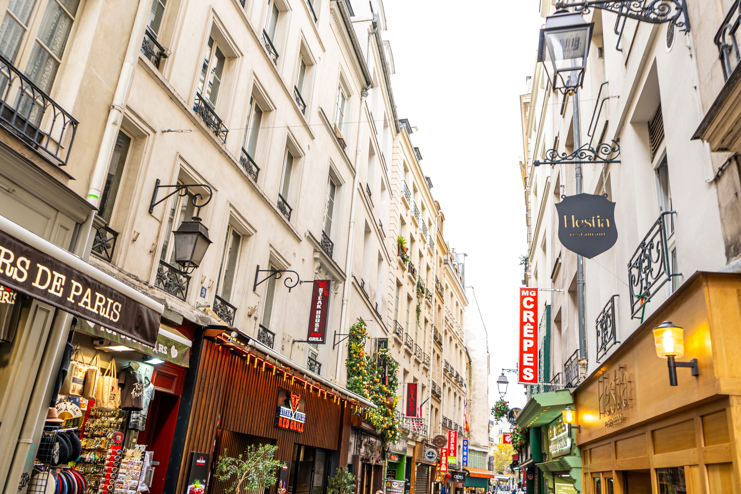 Paris shops logo signboard. Old narrow street in center city. Paris, France