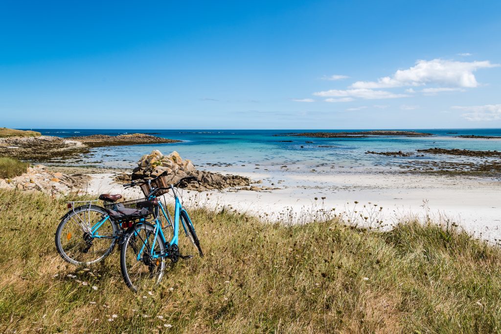 Bicycles parked against the beach in the island of Batz with no people. Summer adventure